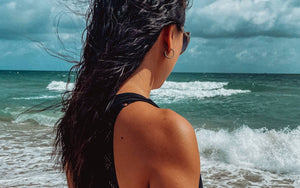 Woman at beach reflecting and looking out into the ocean