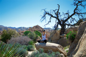 Woman sitting on rock meditating