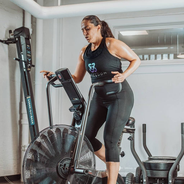 Woman on elliptical wearing black Exhale cropped leggings